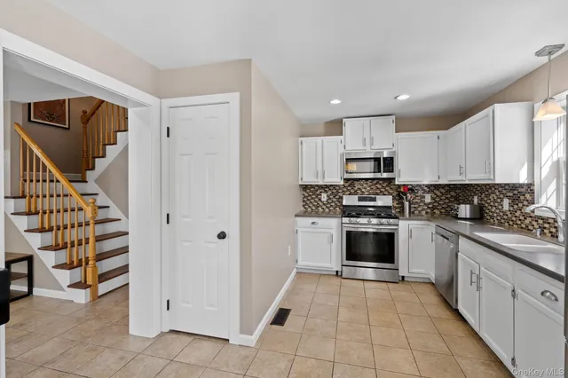 a kitchen with stainless steel appliances granite countertop a sink stove and cabinets