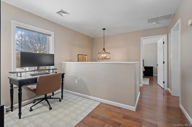 a view of a livingroom with workspace and a window