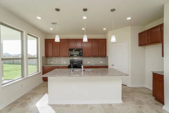 a large kitchen with stainless steel appliances sitting in it