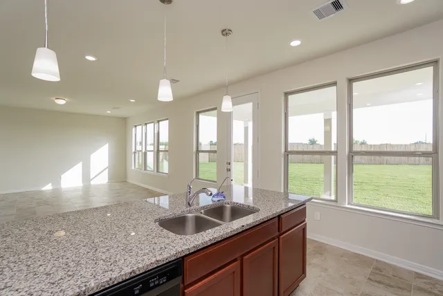 a kitchen with granite countertop a sink and a large window