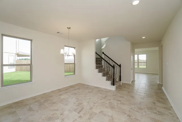 an empty room with windows and stairs