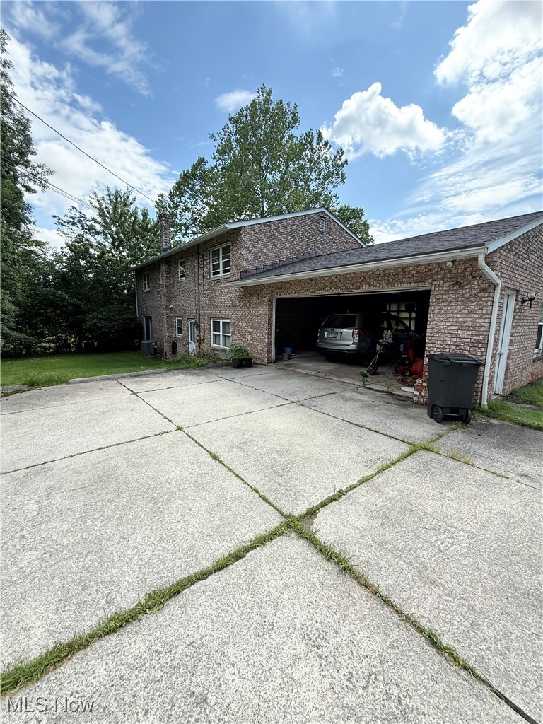 8335 Shepard Road Macedonia, OH 44056 - Photo 2 of 17 View of side of home featuring brick siding, driveway, a chimney, and a garage