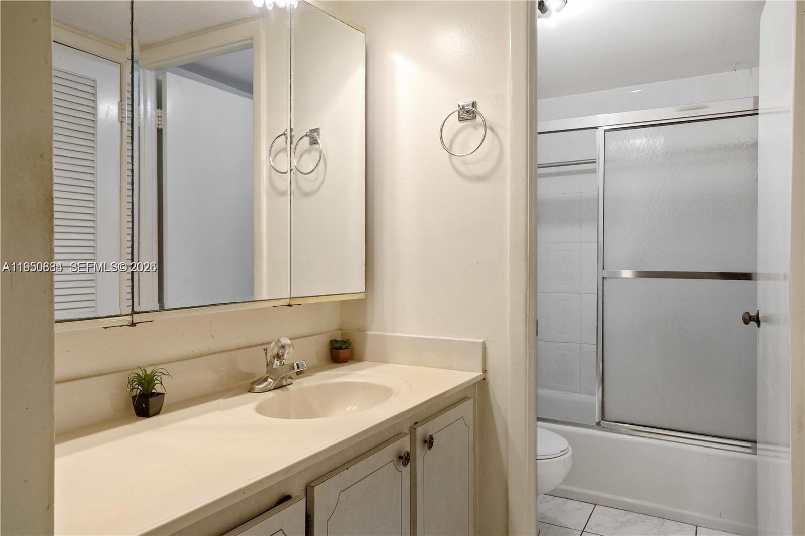 6039 Collins Avenue, Unit 809 Miami Beach, FL 33140 - Photo 12 of 14 a bathroom with a sink and a mirror