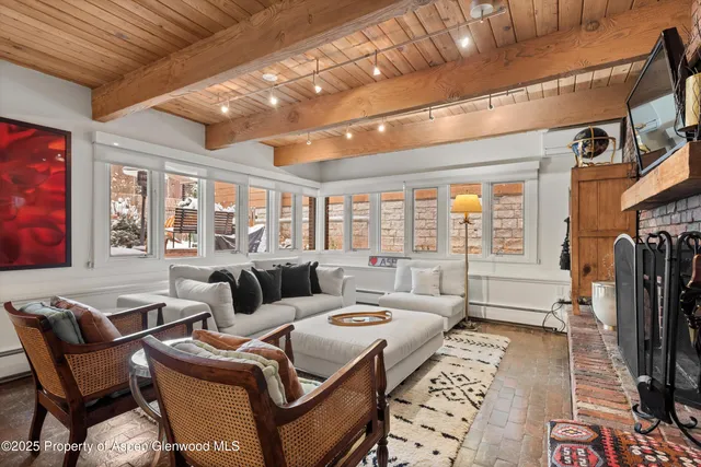 a living room with furniture a flat screen tv and a floor to ceiling window