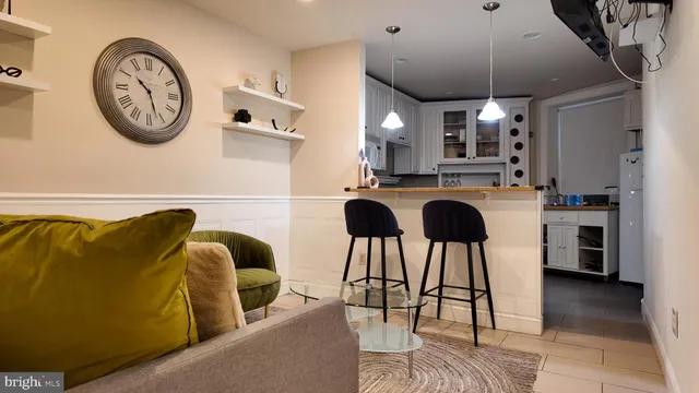 a kitchen with stainless steel appliances granite countertop a table chairs and a clock on the wall