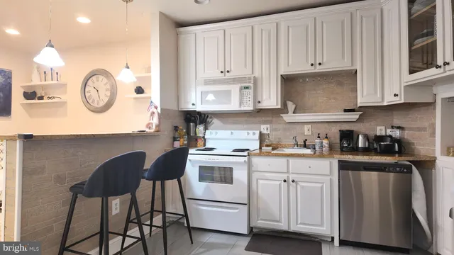 a kitchen with stainless steel appliances granite countertop wooden cabinets a stove a sink and a refrigerator