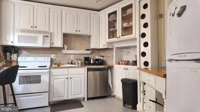 a kitchen with white cabinets and white appliances
