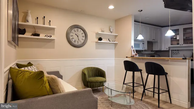 a living room with a couch and a clock on wall