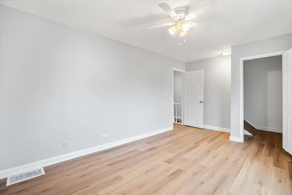 a view of an empty room with wooden floor