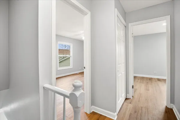 a view of a hallway with wooden floor and staircase