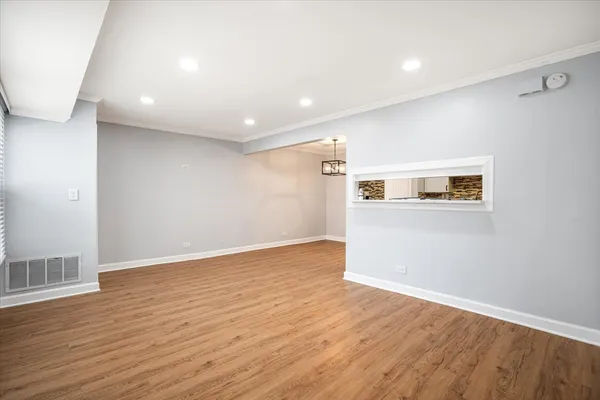 a view of a big room with wooden floor and windows