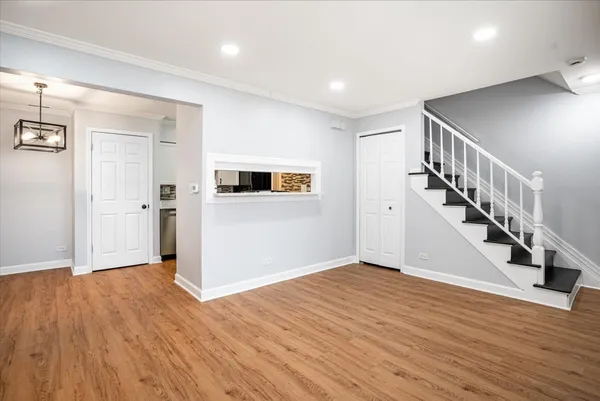 a view of a hallway with wooden floor and staircase