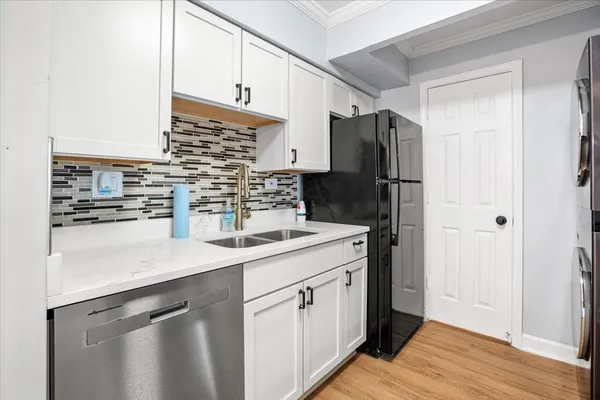 a kitchen with a sink refrigerator and cabinets