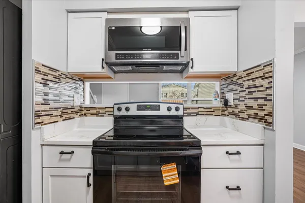 a stove top oven sitting inside of a kitchen