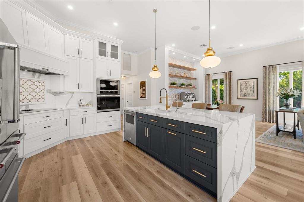 10171 Northwest 59th Drive Parkland, FL 33076 - Photo 1 of 49 a large kitchen with stainless steel appliances kitchen island granite countertop a stove a sink and white cabinets