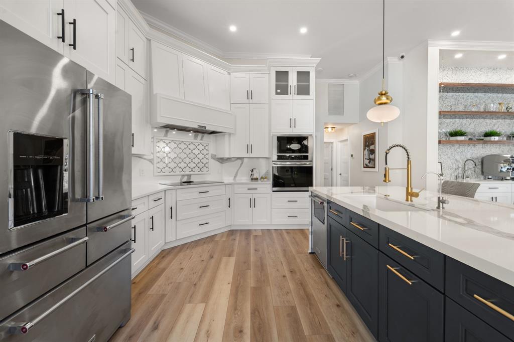 10171 Northwest 59th Drive Parkland, FL 33076 - Photo 22 of 49 a large kitchen with stainless steel appliances granite countertop a lot of counter space and wooden floor