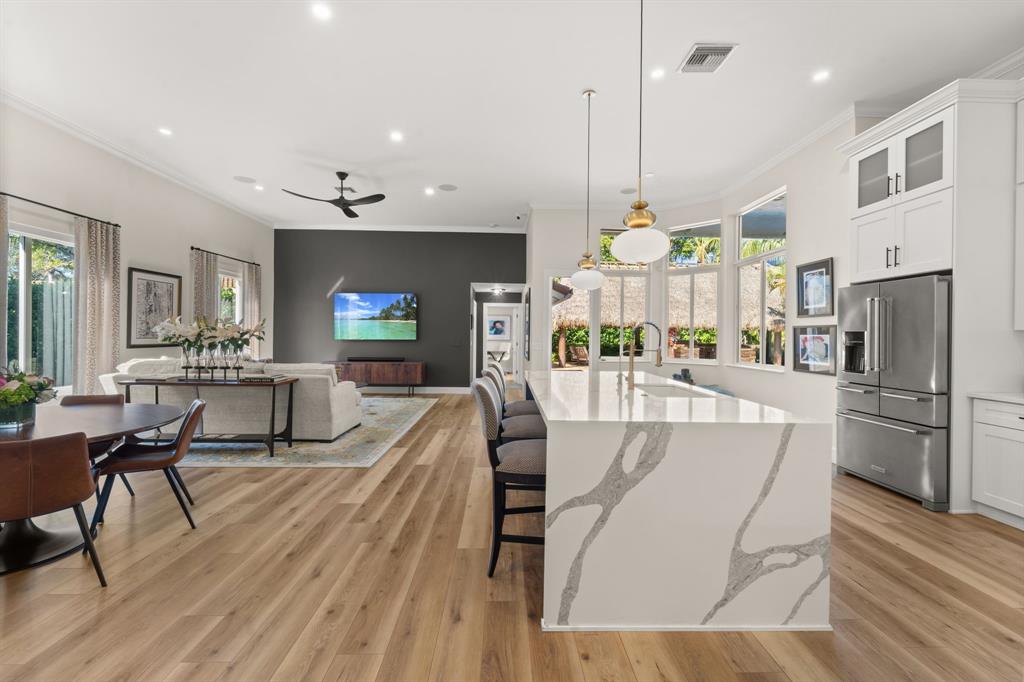10171 Northwest 59th Drive Parkland, FL 33076 - Photo 24 of 49 a large kitchen with stainless steel appliances kitchen island granite countertop a table chairs and a refrigerator