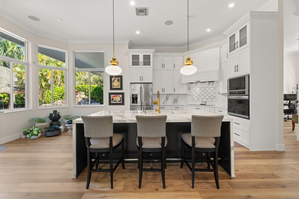 10171 Northwest 59th Drive Parkland, FL 33076 - Photo 26 of 49 a kitchen with a dining table chairs and large windows