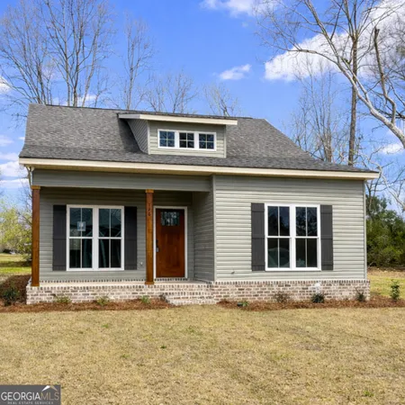 a front view of a house with a garden