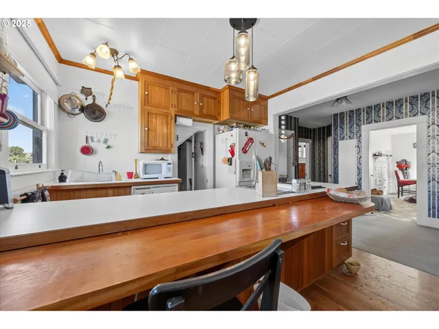 a view of a kitchen with kitchen island stainless steel appliances a sink and living room view