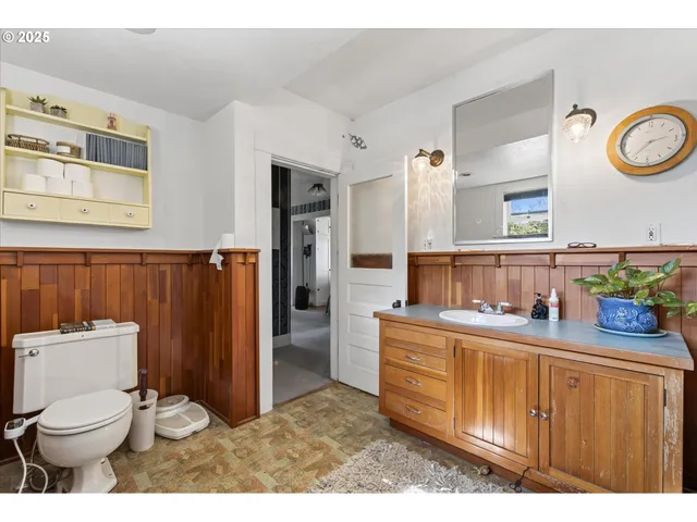 a bathroom with a toilet a sink a vanity and mirror