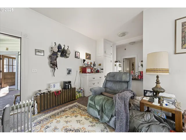 a living room with furniture a baby crib and a wooden floor