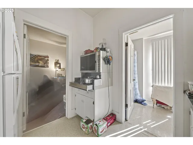 a living room with furniture a flat screen tv and a view of kitchen