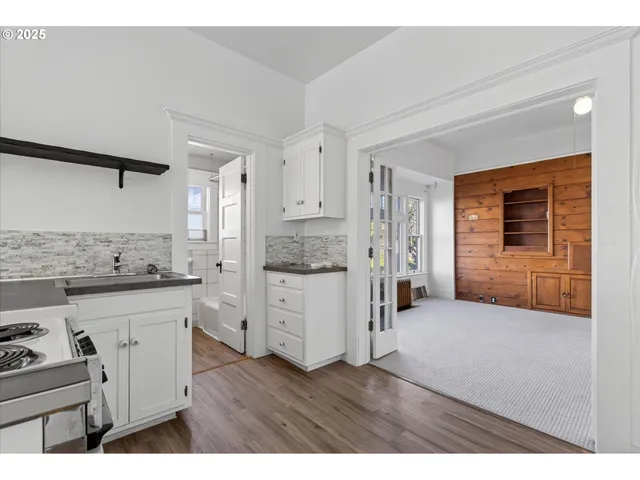 a kitchen with cabinets and wooden floor
