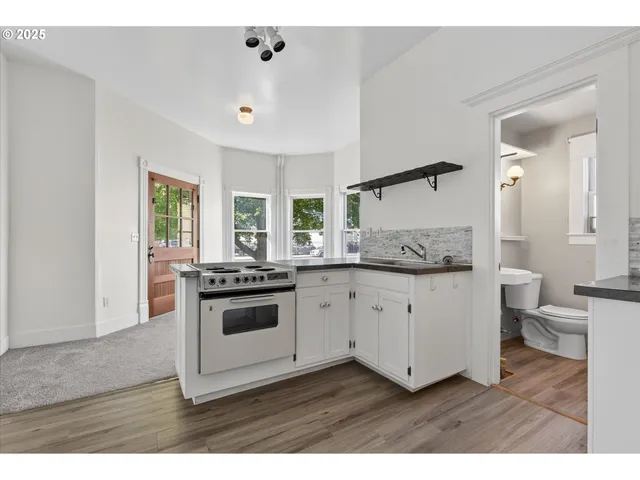 a kitchen with granite countertop white cabinets and white appliances