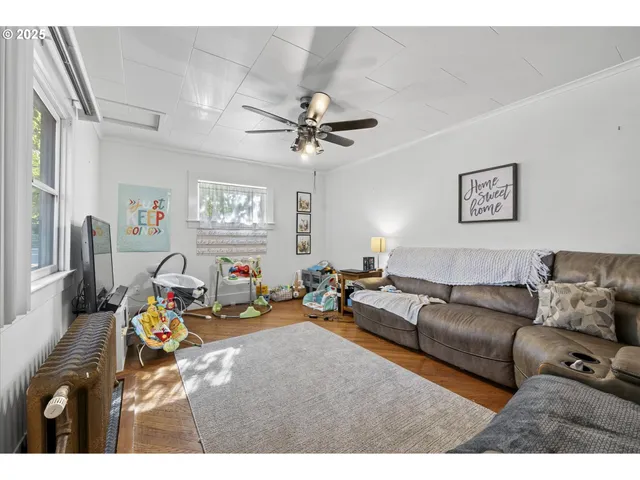a living room with furniture a ceiling fan and a window