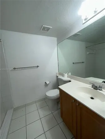 a bathroom with a sink a toilet and mirror