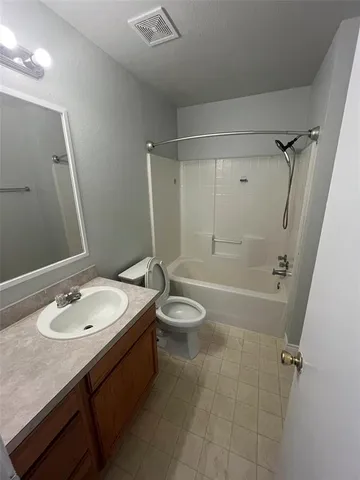a bathroom with a granite countertop sink toilet a mirror and shower