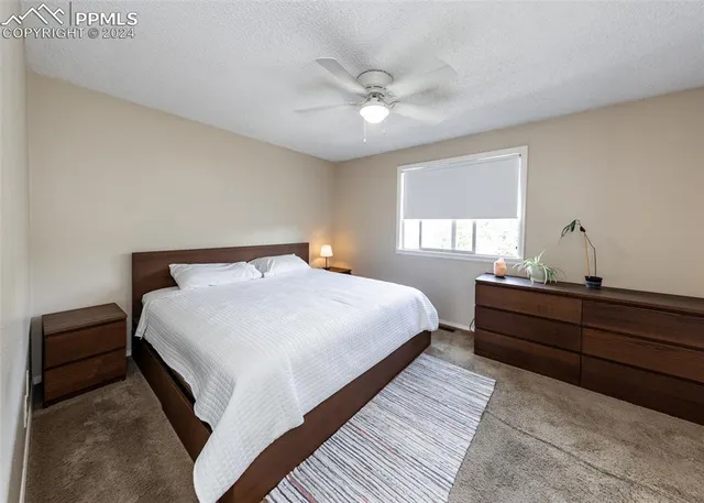 an empty room with a window and ceiling fan