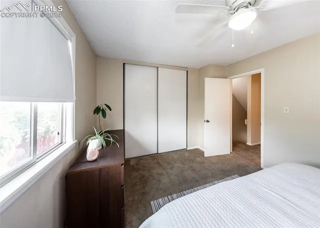 a view of an empty room with a chandelier fan