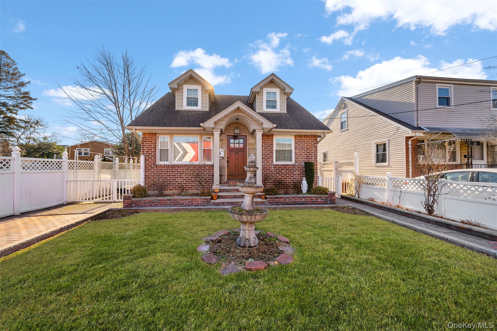 a front view of a house with a garden and lake view