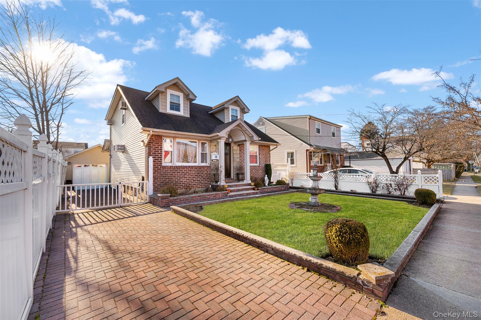 215 Rudolf Road Mineola, NY 11501 - Photo 2 of 14 a front view of a house with a garden and yard