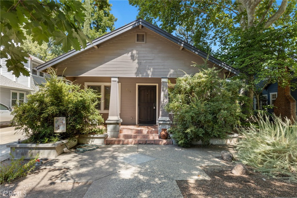 a front view of house with yard and trees around
