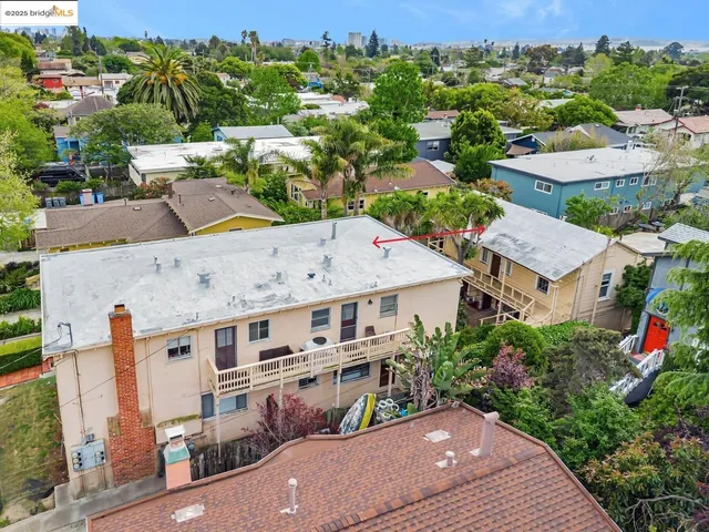 an aerial view of multiple houses with a yard