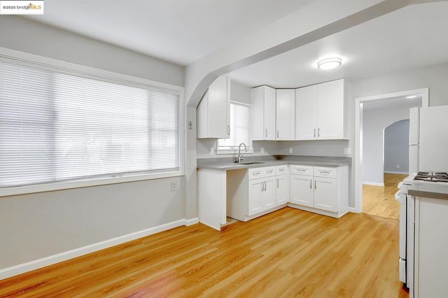 a kitchen with granite countertop white cabinets and white appliances