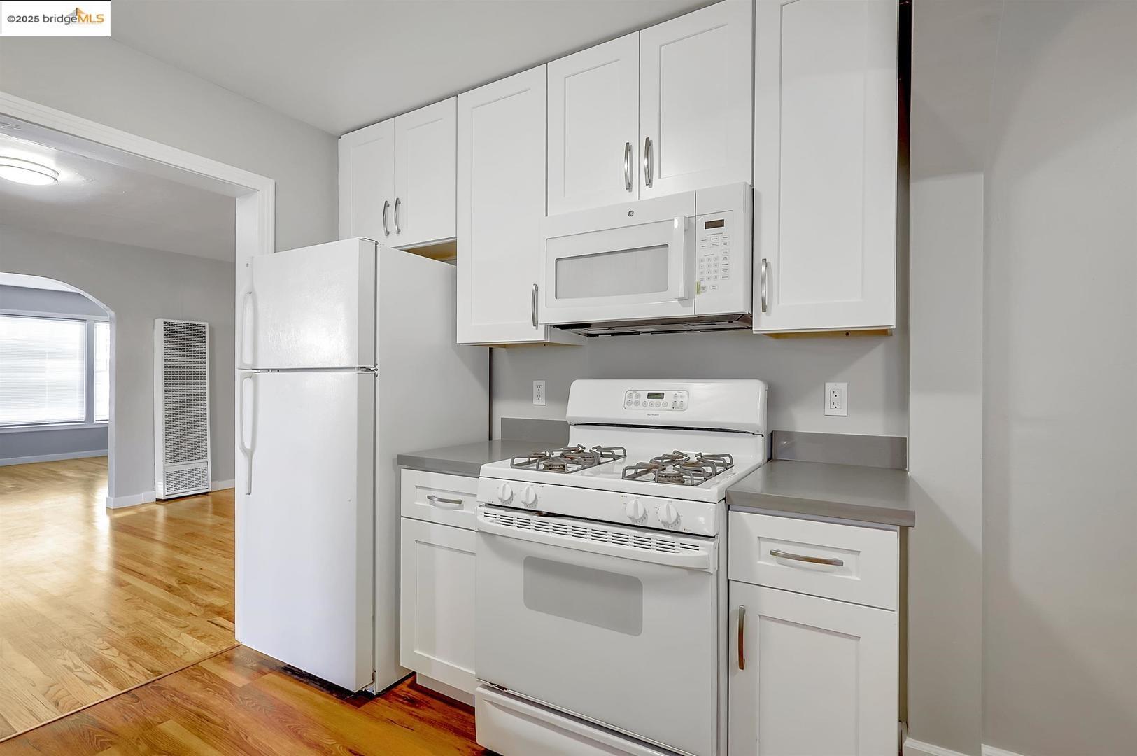 2118 California Street Berkeley, CA 94703 - Photo 27 of 34 a kitchen with white cabinets and white appliances