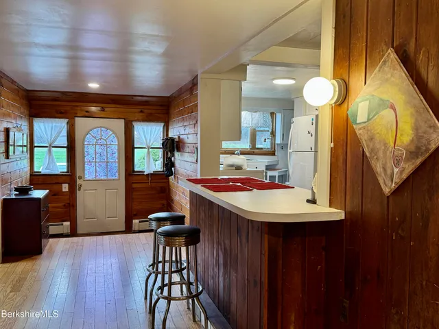 a room with furniture a large window and wooden floors