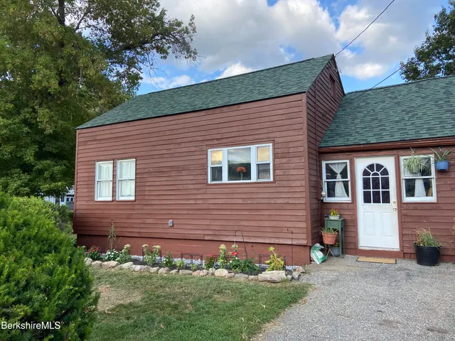 a front view of a house with a garden