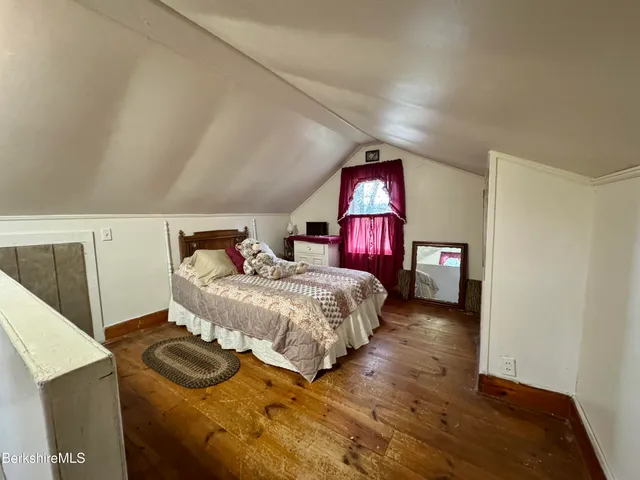 a bedroom with a bed and a potted plant on dresser