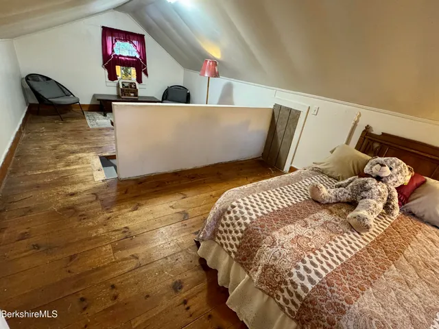 a bed sitting in a bedroom and painting on the wall