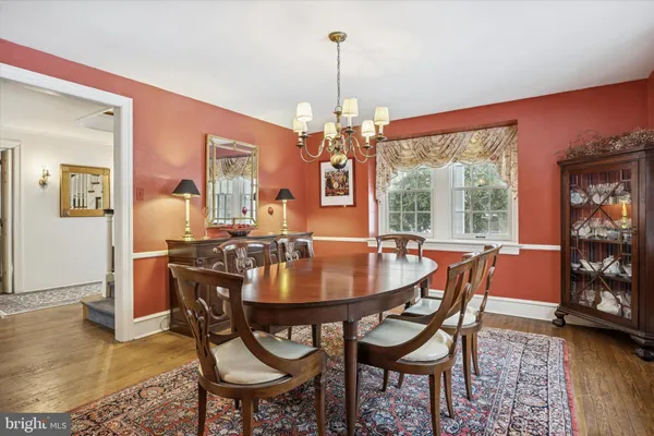 a dining room with furniture a chandelier and wooden floor