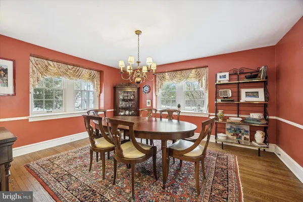 a dining room with furniture a chandelier and wooden floor