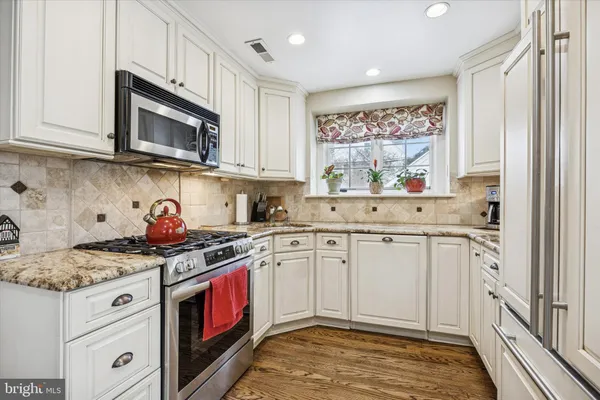 a kitchen with stainless steel appliances granite countertop a stove a sink and a microwave