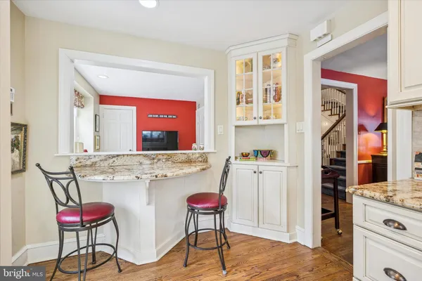 a kitchen with stainless steel appliances kitchen island granite countertop a stove a refrigerator and chairs