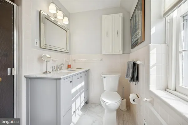 a bathroom with a toilet sink a mirror and vanity