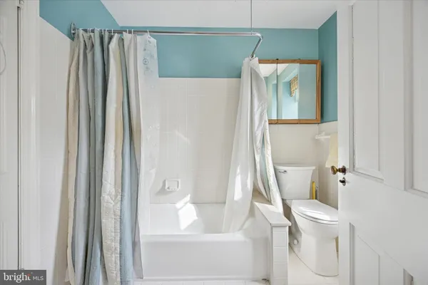 a white toilet sitting next to a bathroom sink and tub